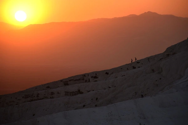 sunset in Turkey with two silhouettes climbing down