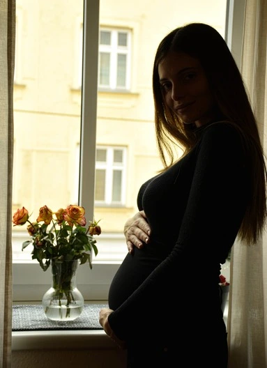 maternity portrait of young woman looking at camera